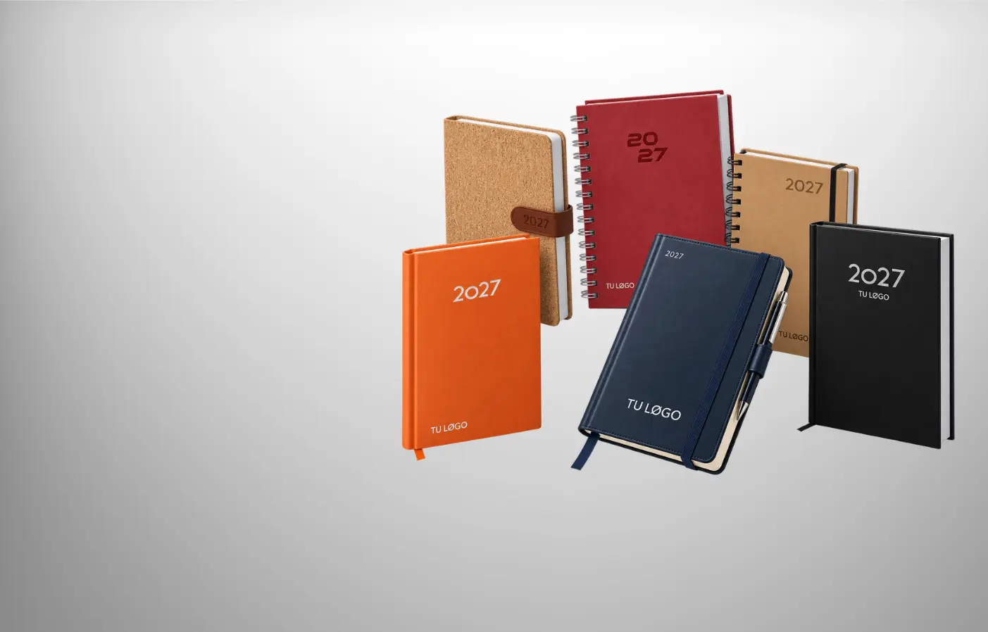 Varias agendas corporativas personalizadas con distintas portadas sobre una mesa de trabajo